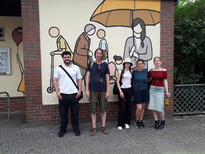 Eine Gruppe Menschen vor einer bemalten Fassade