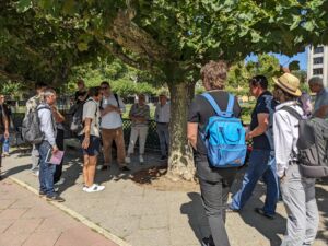 Eine Gruppe von Menschen steht um einen Baum herum.