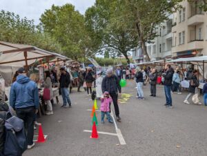 Ein Straßenfest mit Marktständen und Menschen.