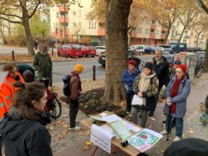 Eine Gruppe Menschen steht um einem Baum herum